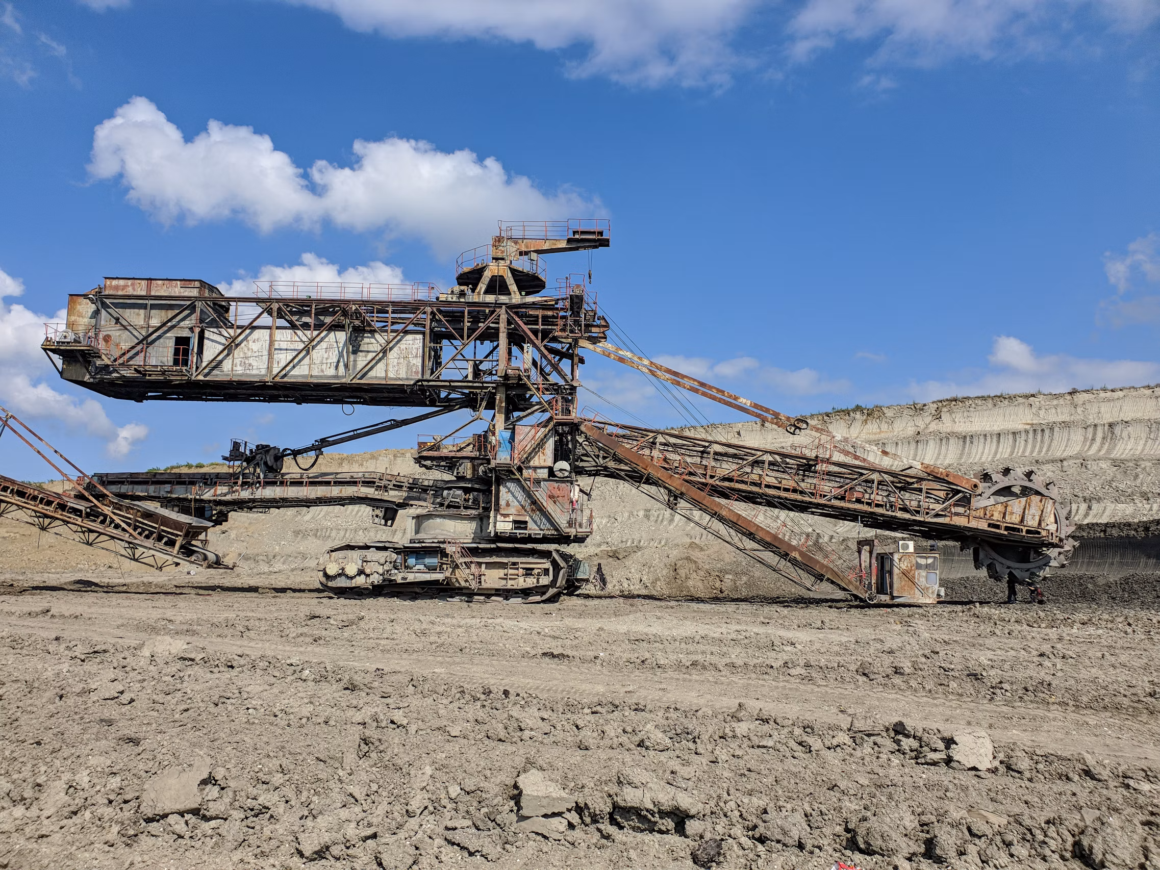 Heavy industrial tracked mineral spreader and excavator machine in open-cast mining basin
